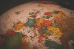 Глобус, илюстриращ процеса на кандидатстване за ипотека с доходи от Германия за имот в Южна Европа.